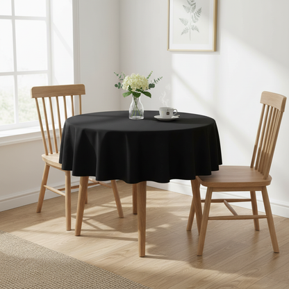 Black Square tablecloth on a small kitchen table with turned wooden legs in a bright cosy UK home setting with flowers and tea