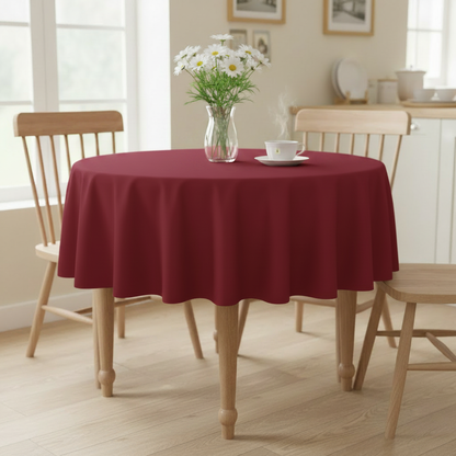 Cherry red Square tablecloth on a small kitchen table with turned wooden legs in a bright cosy UK home setting with flowers and tea