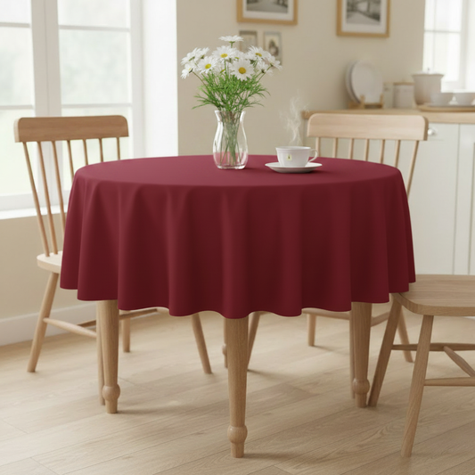 Cherry red Square tablecloth on a small kitchen table with turned wooden legs in a bright cosy UK home setting with flowers and tea